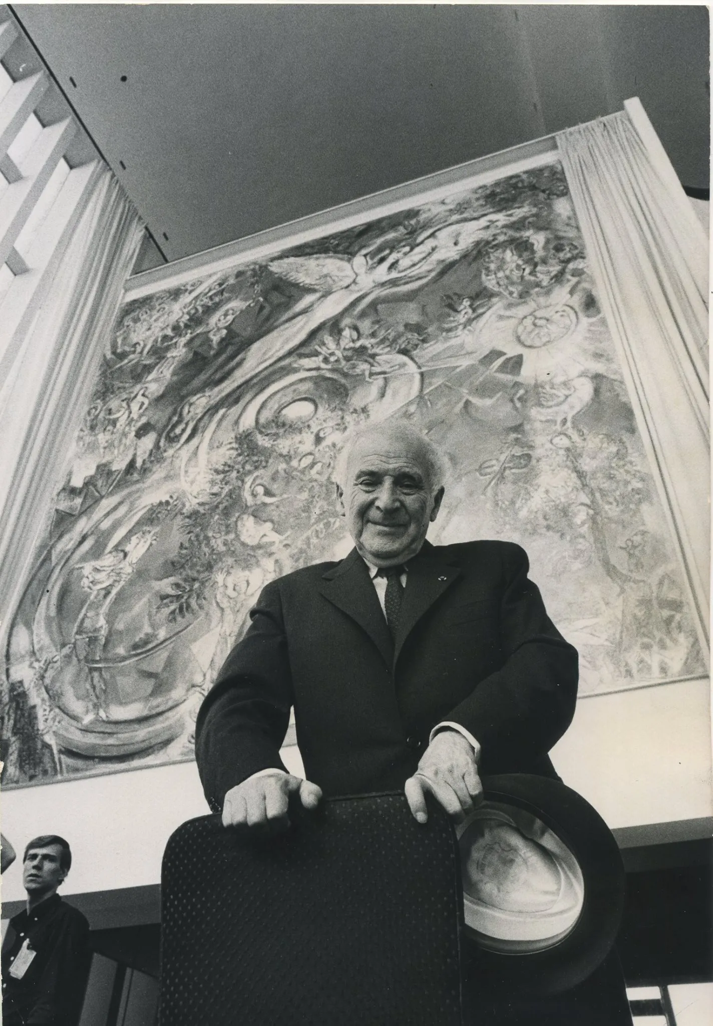Marc Chagall stojí pred farebnou nástennou maľbou v priestore Metropolitnej opery v New Yorku.