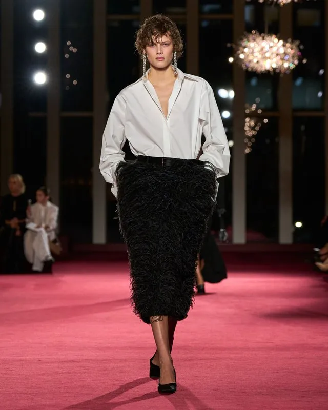 Modelka na prehliadke Michael Kors A/W 26 vo vrstvách elegantných kabátov a klubových siluetách počas New York Fashion Week.