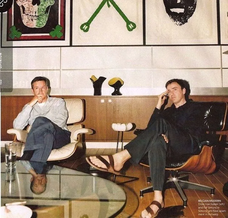 Dries Van Noten a Raf Simons sedia v súkromnom interiéri v Antverpách, klasické Eames lounge stoličky, Mike Kelley obrazy a Pol Chambost vázy.