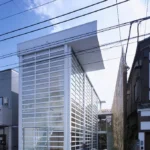 Glass Shutter House od Shigeru Ban v Tokiu s pohyblivými sklenenými panelmi a otvorenou fasádou.