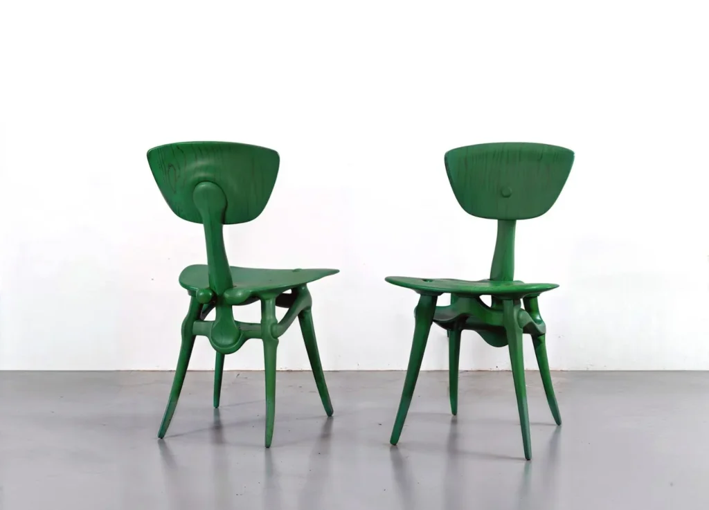 Misha Kahn, IZK Chairs – dve zelené organické drevené stoličky s biomorfnými nohami, 5VIE Design District, Armonie Invisibili, Milan Design Week 2025.