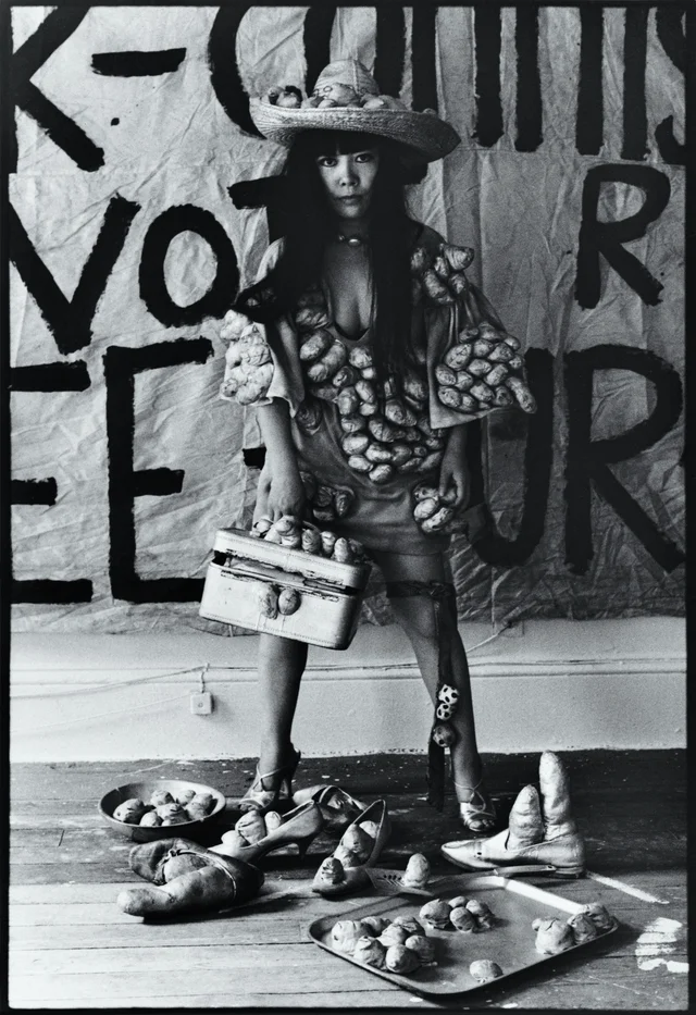 Yayoi Kusama stojí pred veľkým graffiti nápisom, obalená tekvicami, Museum Ludwig Kolín 2026
