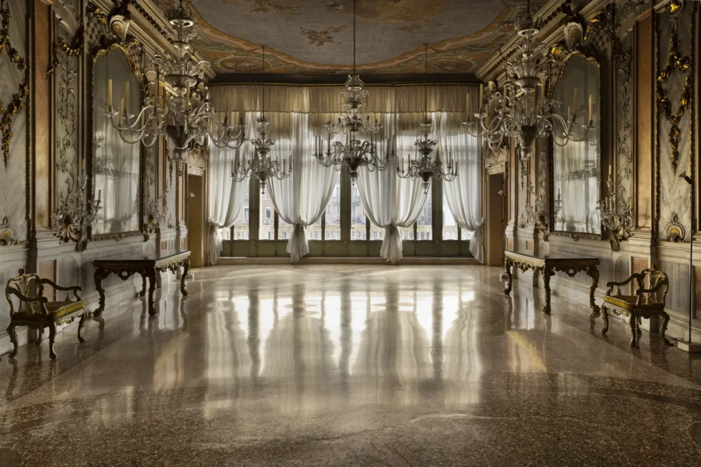 Interiér historického Palazzo Pisani Moretta v Benátkach so zlatými štukovými stenami, lustrami a freskami, sídlo Fondazione Dries Van Noten 2026
