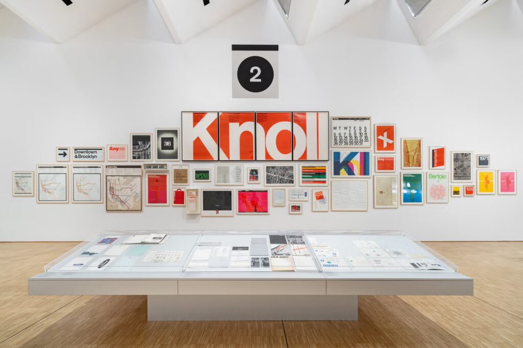 Vignelli dizajn — inštalačný pohľad výstavy Triennale Milano 2026, grafické práce a plagáty vrátane identity Knoll na bielej stene.