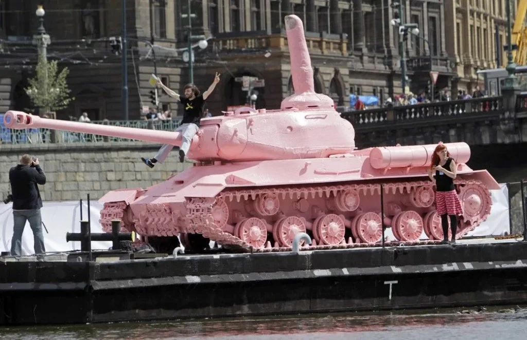 Ružový tank č. 23 Davida Černého na člne na Vltave v Prahe, s turistami fotografujúcimi sa vedľa neho, 2011.