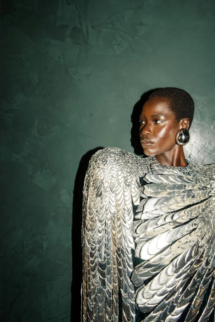 Model Awar Odhiang v Schiaparelli Haute Couture jeseň/zima 2024, strieborný odev s motívom perí. Foto: Kuba Dabrowski.
