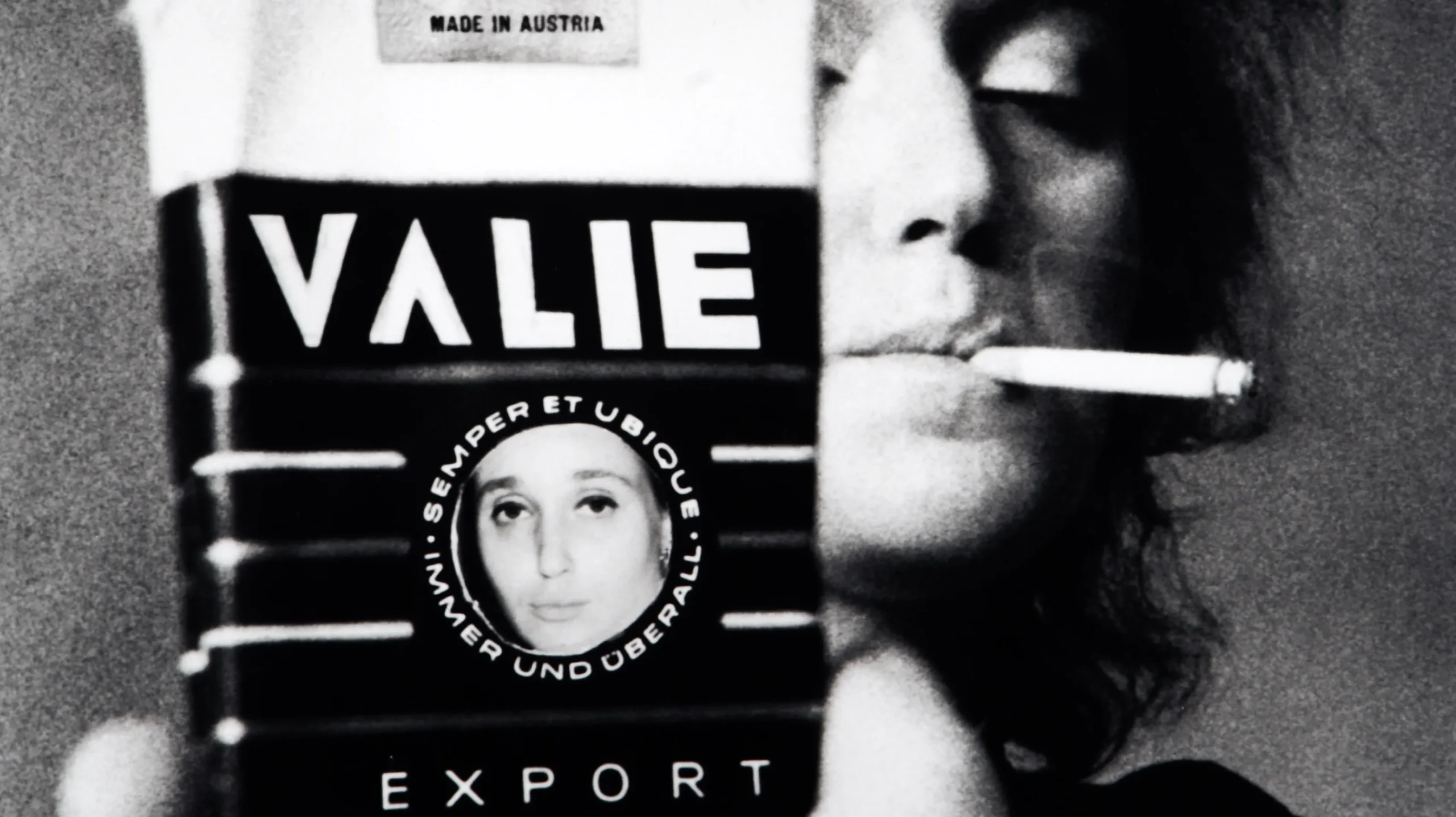 Valie Export, Smart Export, Selbstporträt, 1970. Čiernobiela fotografia umelkyne s cigaretou a krabičkou cigariet Smart Export s jej portrétom.