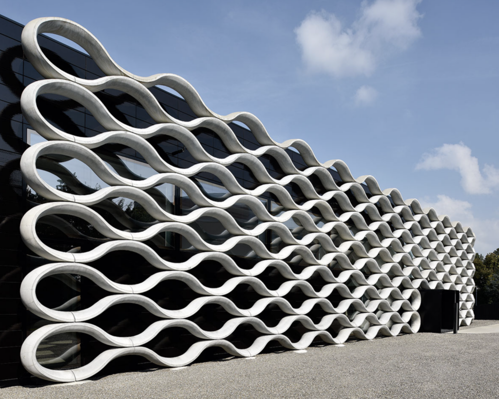 Fasáda budovy Galeriehalle v areáli Bischofberger v Zürichu s betónovými vlnovkami tvorenými do trojrozmernej siete, návrh Baier Bischofberger Architects