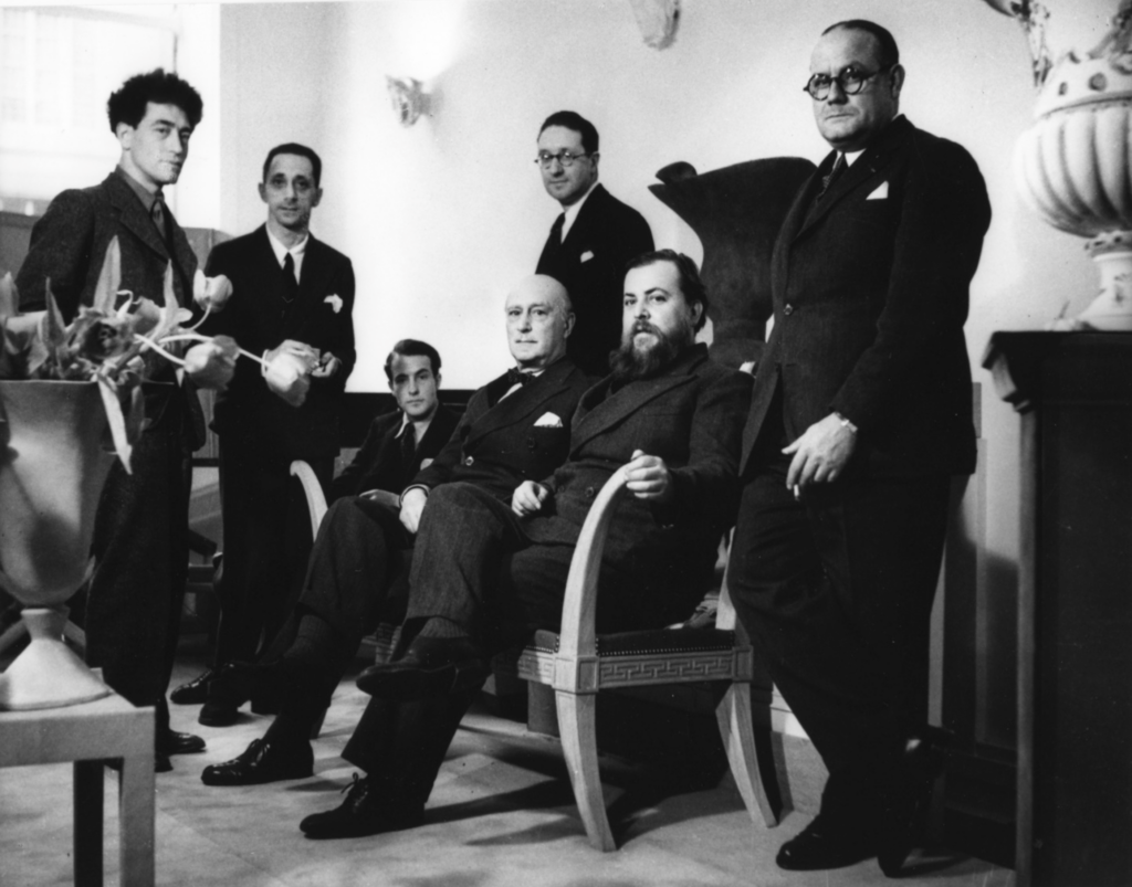 Archívna skupinová fotografia z boutique Jeana-Michela Franka okolo roku 1935, Alberto Giacometti stojí vľavo, vedľa neho Jean-Michel Frank, Diego Giacometti a ďalší spolupracovníci
