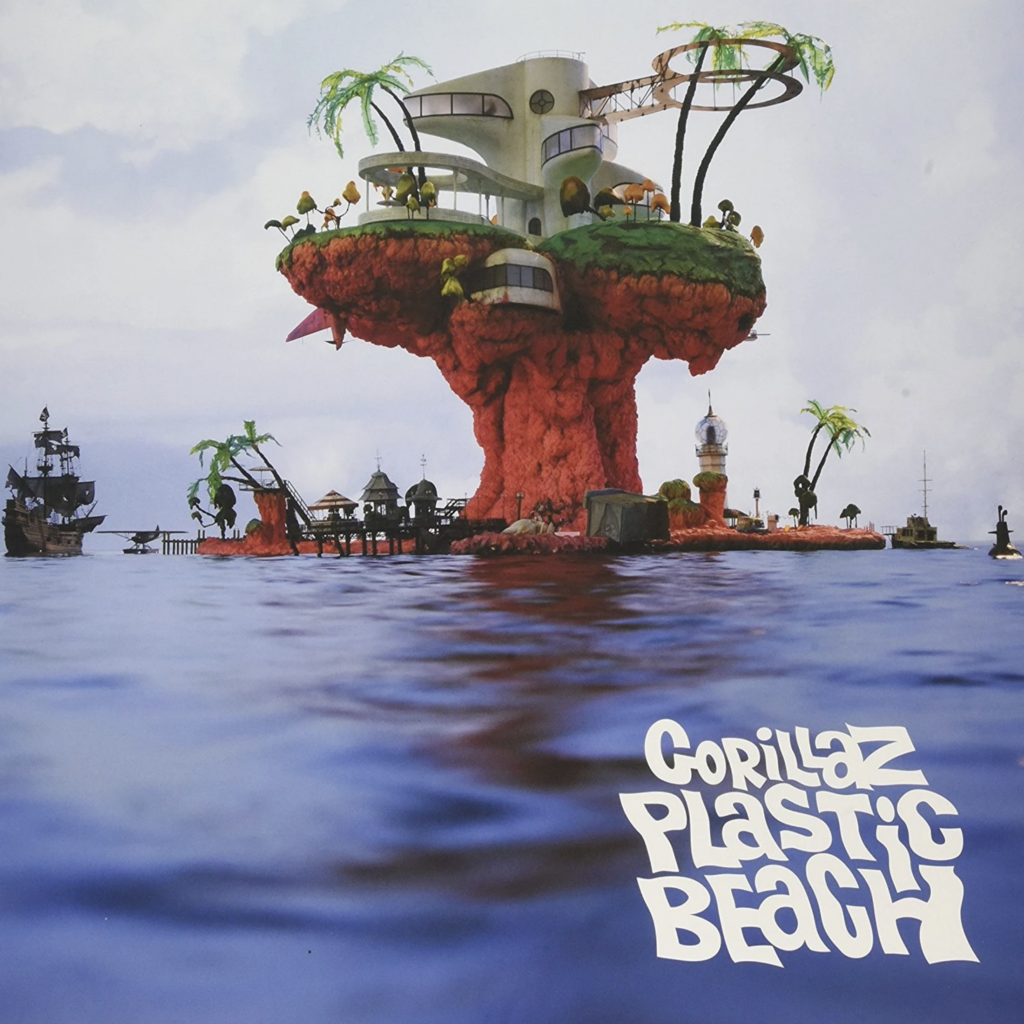 Obal albumu Plastic Beach od Gorillaz z roku 2010 s ilustráciou ostrova z odpadu uprostred mora, nad ktorým stojí budova Kong Studios