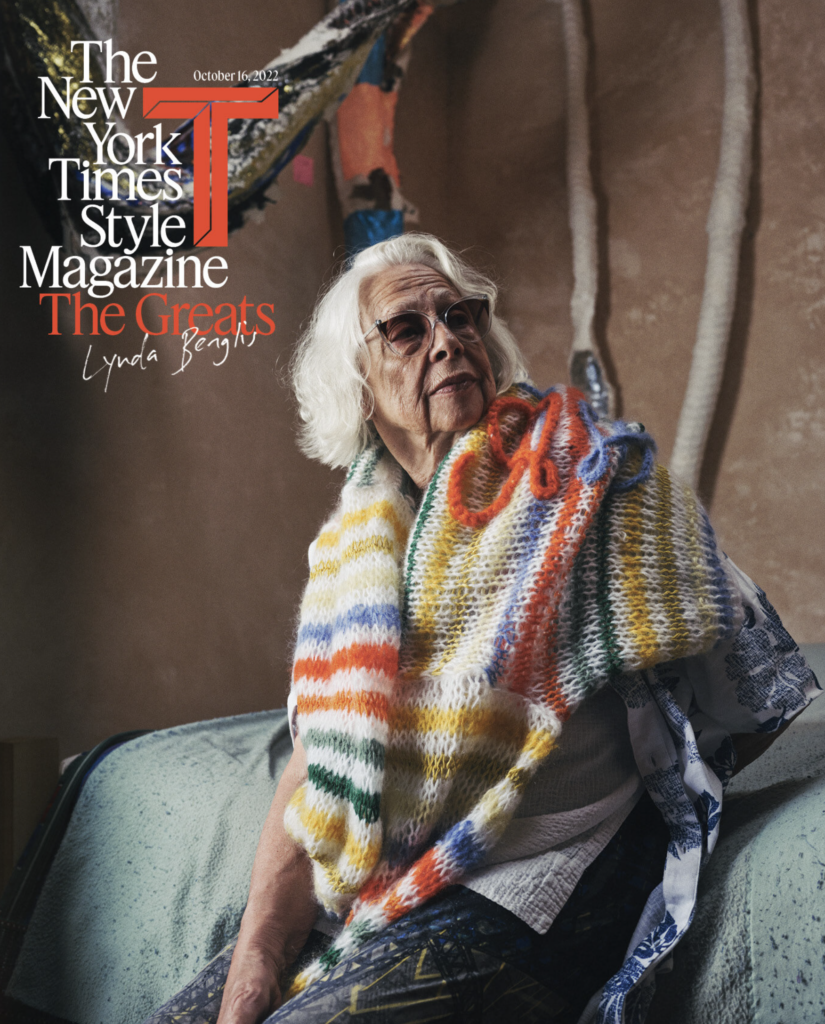 Lynda Benglis sedí vo svojom ateliéri v Santa Fe, cez plecia má prehodenú pestrofarebnú pletenú prikrývku, v pozadí visí socha z farebných textilných pásov