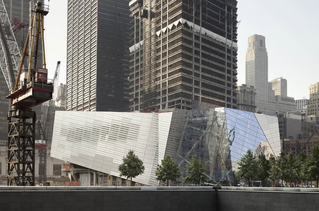 Pavilón Národného múzea 11. septembra od Snøhetty s fazetovanou sklenenou a nerezovou fasádou medzi mrakodrapmi dolného Manhattanu