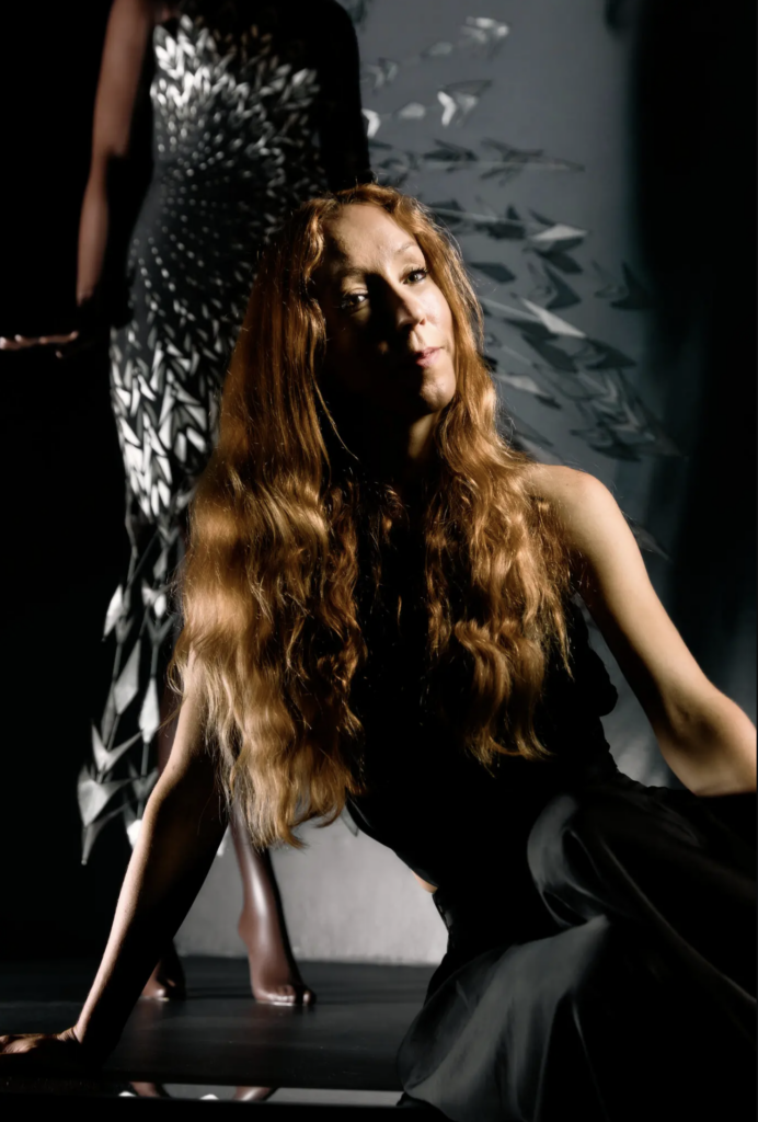 Iris van Herpen pred geometrickými šatami vo svojej inštalácii v Brooklyn Museum