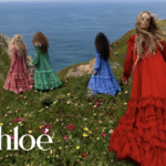 Modelky vo farebných šatách Chloé stojace na útese s výhľadom na more