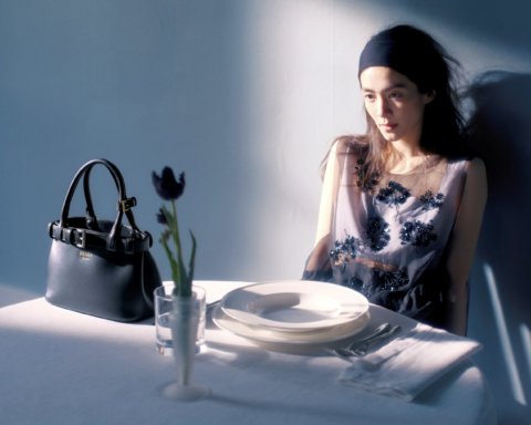Herečka Chen Haoyu sedí pri prestretom stole s kabelkou Prada Buckle Bag, filmový záber z kampane Simple Stories