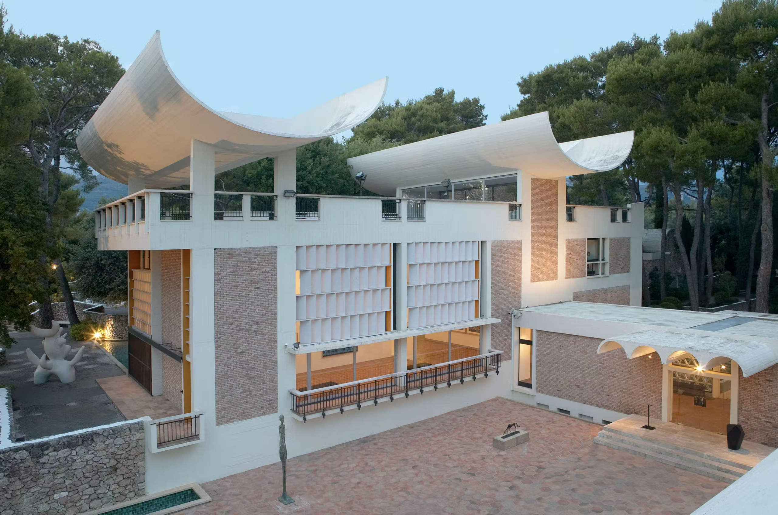 Exteriér Fondation Maeght s charakteristickou zvlnenou strechou a Giacomettiho sochou na nádvorí