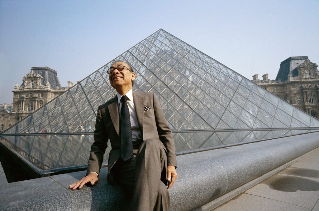 Architekt I. M. Pei sedí pred sklenenou pyramídou Louvru, ktorú navrhol