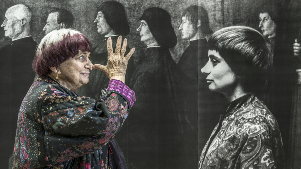 Agnès Varda gestikuluje pred veľkoformátovou fotografickou nástennou maľbou vo filme Faces Places