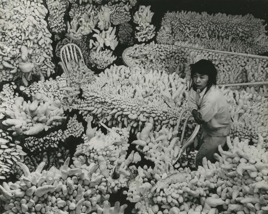 Yayoi Kusama uprostred svojej inštalácie Compulsion Furniture (Accumulation), pokrytej tisíckami výčnelkov