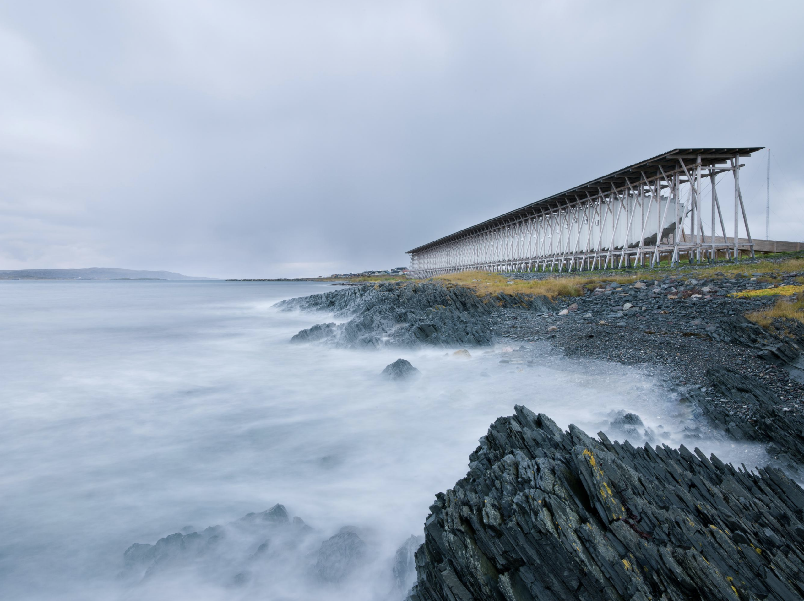 Steilneset Memorial od Petra Zumthora, dlhá drevená konštrukcia na kamenistom pobreží pri Vardø