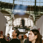 Návštevníci Art Basel Paris prechádzajú uličkami stánkov pod presklenou kupolou Grand Palais