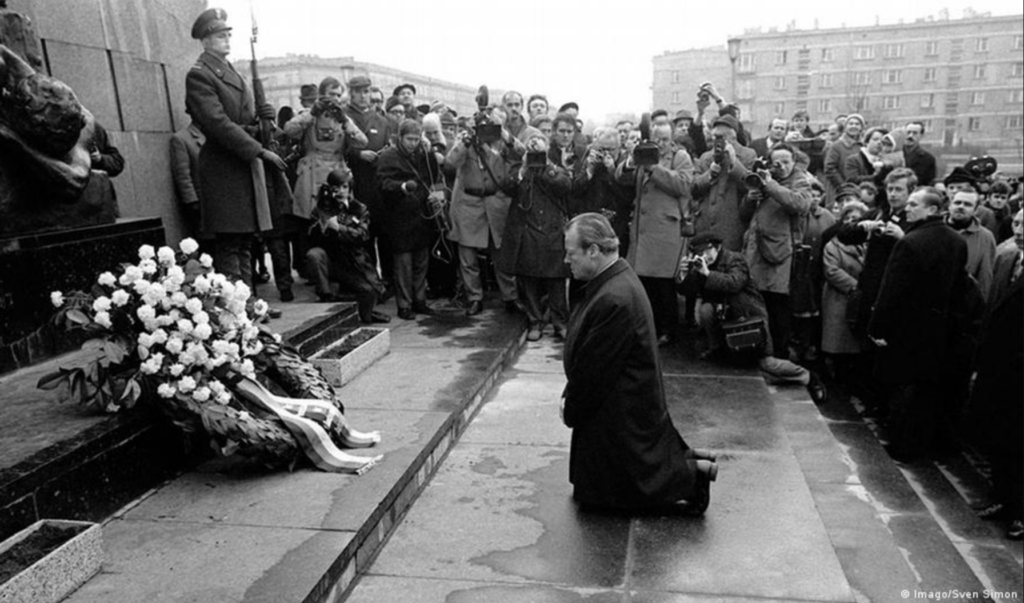 Willy Brandt kneeling before the Warsaw Ghetto memorial, surrounded by photographers, 1970