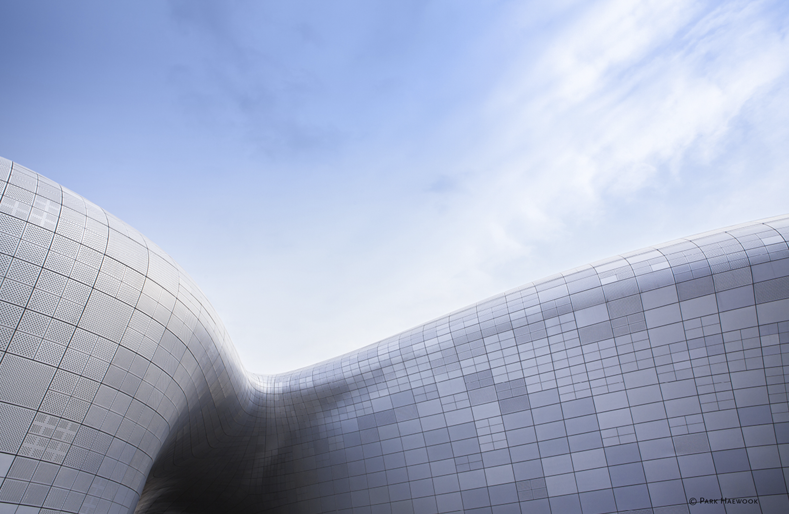 Plynulý zvlnený tvar fasády Dongdaemun Design Plaza od Zahy Hadid