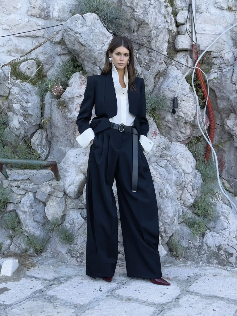 Kaia Gerber v čiernom obleku Givenchy na skalnatom pobreží