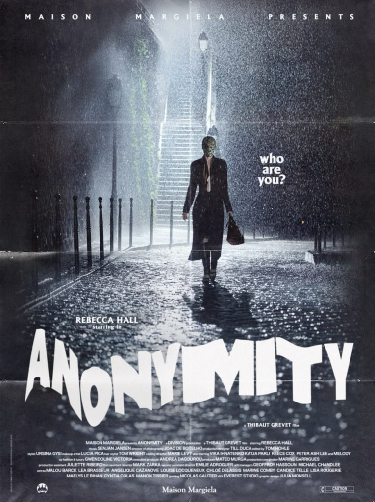 Filmový plagát ANONYMITY s Rebeccou Hall v maske, kráčajúcou v daždi