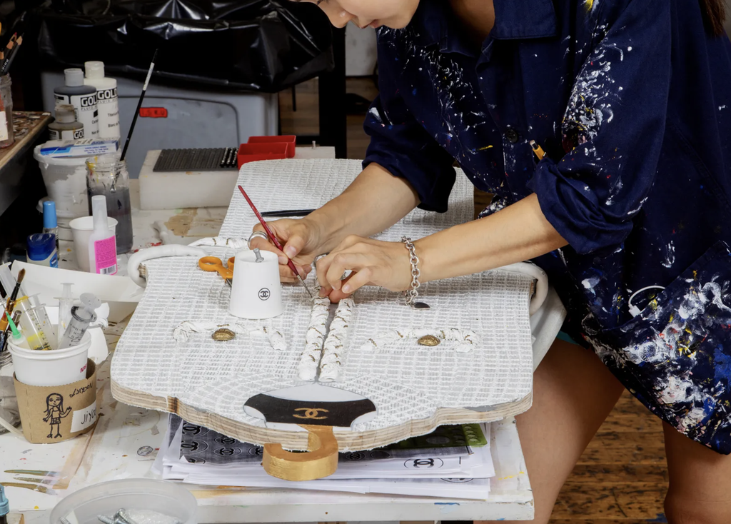 A staff member from Tom Sachs's studio working on the tweed suit "Anna"