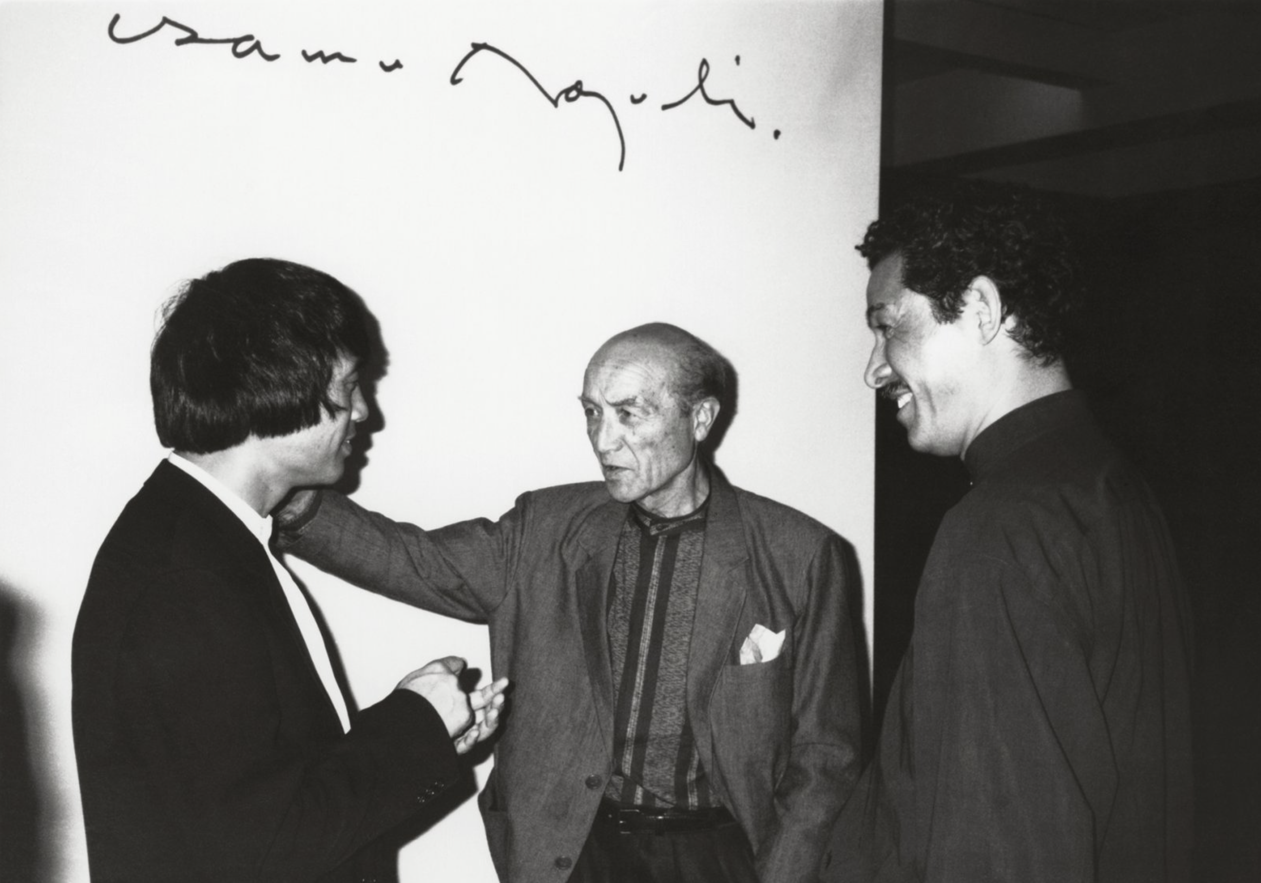Čiernobiela fotografia Issey Miyakeho, Isamu Noguchiho a Tadaa Anda v rozhovore v New Yorku v roku 1988.
