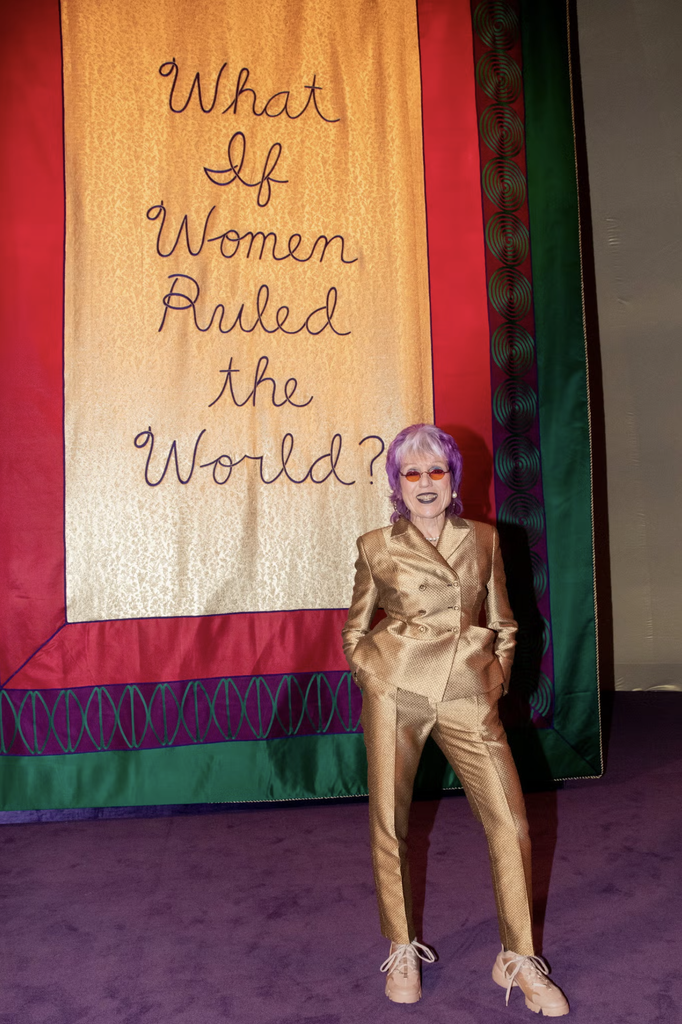 Judy Chicago pred jedným zo svojich transparentov v priestore prehliadky Dior haute couture jar 2020. Foto: Kevin Tachman